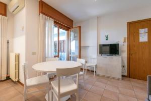 a dining room with a white table and chairs at Residence Piccolo in Milano Marittima