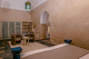 a room with two beds and a table and chairs at Prestige du Souss in Oulad Berhil