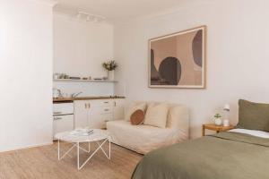 a bedroom with a bed and a couch and a table at The Lane - Byron Bay in Byron Bay +5 photos