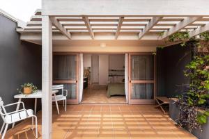 an outdoor patio with a pergola and a table and chairs at The Lane - Byron Bay in Byron Bay