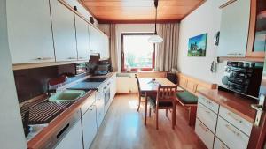 シュピールベルクにあるHaus am Ringの白いキャビネットとテーブルと椅子のあるキッチン