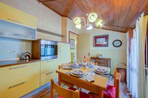 cocina con mesa de madera y comedor en Cosy Loft 500m From Sea - Happy Rentals, en Alassio