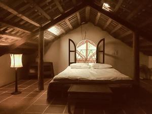 a bedroom with a bed in a room with a window at Ancient House Cat Ba in Hai Phong