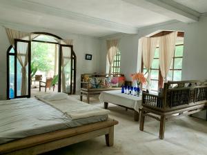 a bedroom with two beds and a table and chairs at Ancient House Cat Ba in Hai Phong