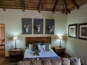 1 dormitorio con 1 cama con cuernos en la pared en Paradise River Lodge, en Hoedspruit