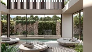 sala de estar con 2 sillas y piscina en PEARL ISLAND CHIOS HOTEL & SPA en Chios