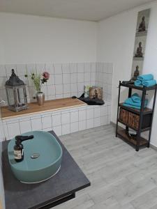 ein Badezimmer mit einem blauen Waschbecken auf der Theke in der Unterkunft Ferienwohnung Waldeule in Bad Kissingen