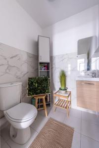 een badkamer met een toilet, een wastafel en een spiegel bij Disney Skyline Suite in Bussy-Saint-Georges