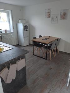 eine Küche mit einem Tisch und Stühlen sowie einem Kühlschrank in der Unterkunft Ferienwohnung Waldeule in Bad Kissingen