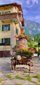 a flower cart with flowers in front of a building at Albergo Piani di Luzza in Forni Avoltri