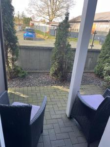 een patio met 2 stoelen en een auto in een tuin bij Hotel Gasthof Handewitt in Handewitt
