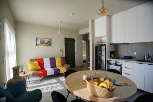 a kitchen and living room with a table with a basket of fruit at Petousis Villas in Galatás