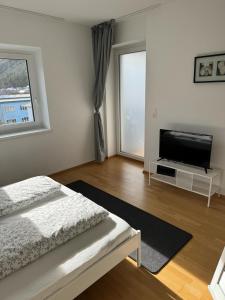 a bedroom with a bed and a flat screen tv at Appartement Emat 13 in Telfs