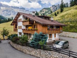 a house with a car parked in front of it at Chalet Pradat in Arabba