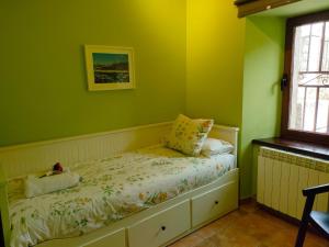 エル・ベルエコにあるAlojamiento Antigua Casa de Telefonosの緑の壁のベッドルーム1室、ベッド1台(枕付)