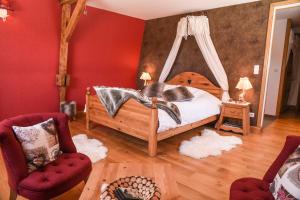 1 dormitorio con cama y pared roja en Le Domaine des Fagnes, en Sains-du-Nord