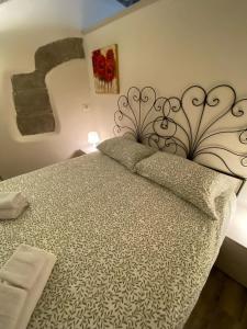1 dormitorio con 1 cama con cabecero de metal en DOMUS TUSCIA APARTMENTS Via Piana 1, en Viterbo