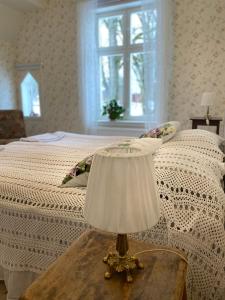 1 dormitorio con 1 cama y 1 mesa con lámpara en Himmelskällan, en Varnhem