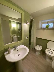 Un baño con lavabo, inodoro y espejo. en DOMUS TUSCIA APARTMENTS Via Piana 1, en Viterbo