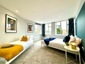 1 dormitorio con 2 camas y mesa en Bournemouth Bliss: 3Bedroom Near Sea & Town Vibes!, en Bournemouth