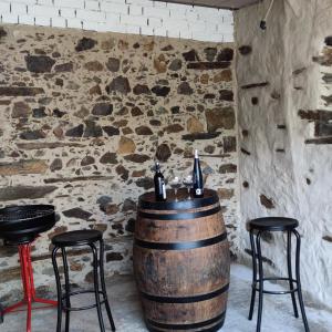 a bar with two stools and a wine barrel at Casa rural La calleja de las hurdes TRCC00555 in Sauceda