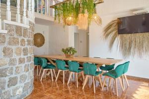 comedor con mesa y sillas verdes en Spacious Villa- Private Pool/ 8BR/@Playa Den Bossa, en Sant Josep de sa Talaia