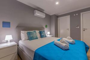 a bedroom with a bed with blue sheets and pillows at NEAR BY THE LAND OF LEGENDs , 40 M2 PRİVATE POOL VİLLA BATİATUS in Belek +23 photos