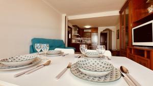 una mesa de comedor con platos y copas de vino en Click&Guest - Bright Sun House with Sea Views, en Agüimes