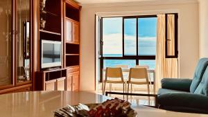 Una sala de estar con una mesa y vista al mar. en Click&Guest - Bright Sun House with Sea Views, en Agüimes