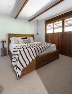 1 dormitorio con 1 cama grande de madera en una habitación en Fig Tree Creek Retreat en The Pocket