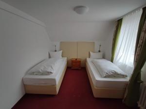 two twin beds in a room with a red carpet at Room in Guest room - Pension Forelle - double room no1 in Forbach