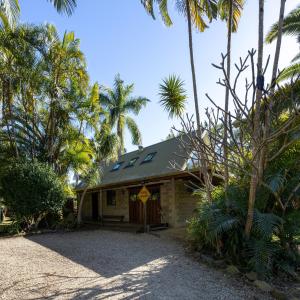 una casa con palmeras delante en Fig Tree Creek Retreat en The Pocket