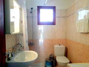 a bathroom with a toilet and a sink and a window at DOURIOS IPPOS Studios in Frikes +6 photos