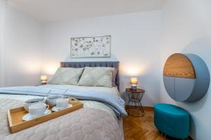 a bedroom with a bed with a tray with cups on it at Angie in Baška