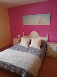 sypialnia z łóżkiem z fioletowymi ścianami w obiekcie Vivienda de uso Turístico LARA 