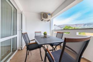 a dining room with a table and chairs on a balcony at Angie in Baška