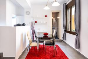 Garden Apartments في Rózia: غرفة طعام مع طاولة وسجادة حمراء