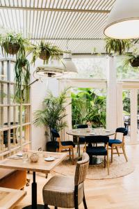 een kamer met tafels, stoelen en planten bij Hotel Pulitzer Barcelona in Barcelona