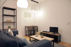 sala de estar con sofá, mesa y TV en Cozy 2 bedrooms apartment in Chamberi (A.M), en Madrid