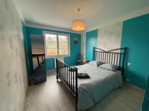1 dormitorio con paredes azules, 1 cama y ventana en À l'orée du bois, en Étaples