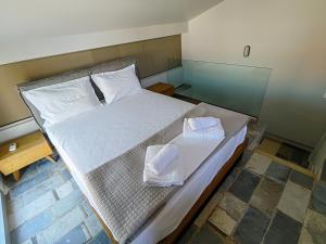 a bedroom with a bed with two towels on it at Bella Vista Apartments Keramoti in Keramoti