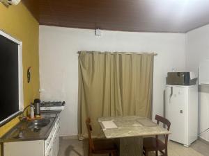 a small kitchen with a table and a refrigerator at Loft privativo . in Macapá