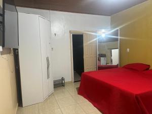 1 dormitorio con cama roja y espejo en Loft privativo ., en Macapá