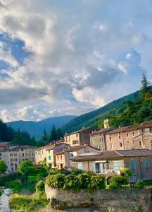 a town with buildings and mountains in the background at Grande maison cévenole authentique in Valleraugue