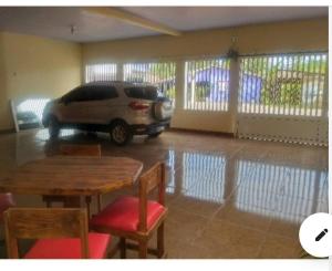 une voiture garée dans un garage avec une table et des chaises dans l'établissement Loft privativo ., à Macapá