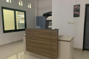 a counter in a room with two windows at OYO 93876 Athirah Kost in Tolo