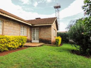 a small brick house with a grass yard at 3BR Serene Bungalow in Lower Kabete in Nairobi