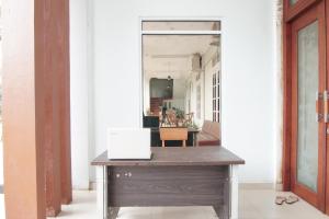un bureau avec un bureau en bois dans le couloir dans l'établissement OYO 93849 Kng Homestay Syariah, à Pekanbaru