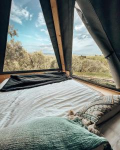 un letto in una tenda che guarda fuori da una finestra di Glamping la lodola a Crocina