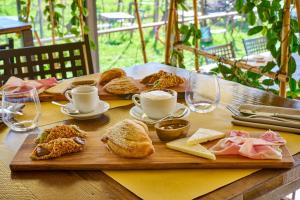 a wooden table with sandwiches and cups of coffee and pastries at La Dama Country Rooms in Monteriggioni